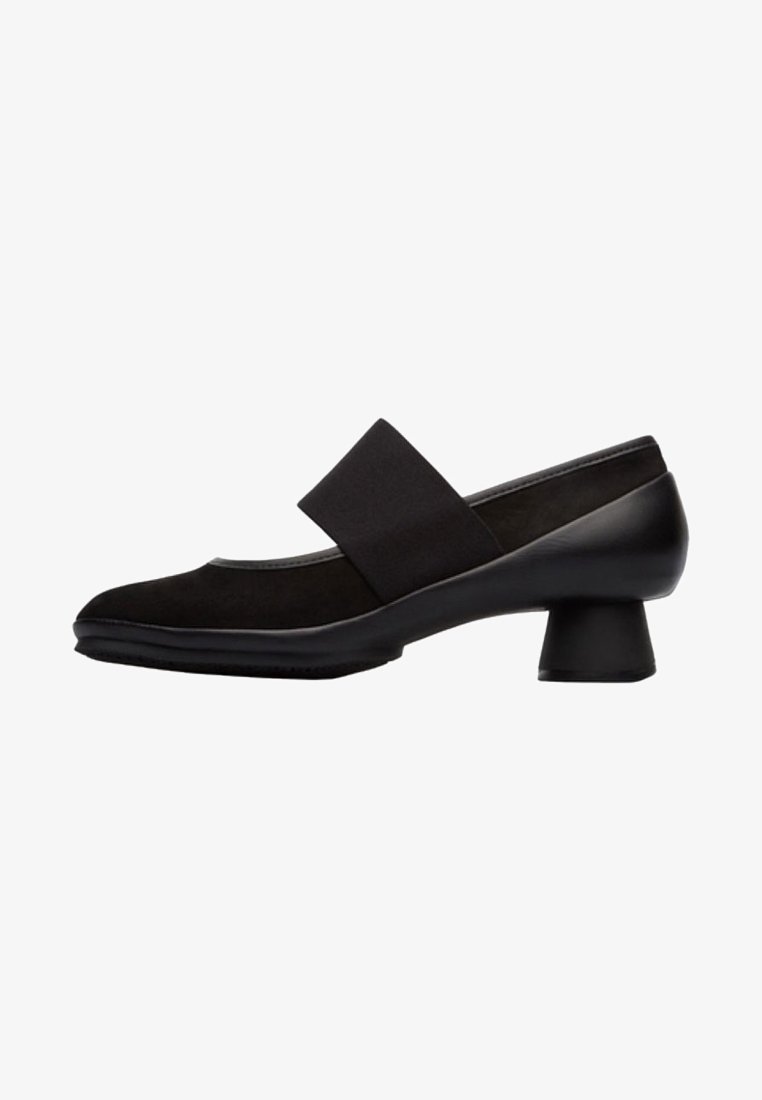 Chaussure Mary Jane noire à talon bas avec large sangle élastique sur le cou-de-pied et bout arrondi.