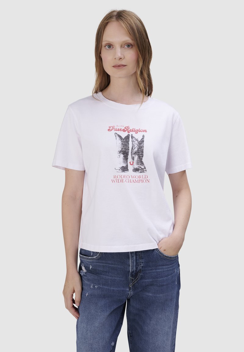 T-shirt en coton blanc à manches courtes avec un imprimé graphique de bottes de cowboy et le texte « True Religion Rodeo World Wide Champion ». 