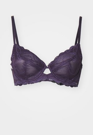 Violeta mežģīņu krūšturis ar stieptām stangām, regulējamiem siksniņām un viļņotu malu. Tam ir izgriezums centrā un caurspīdīga tekstūra.