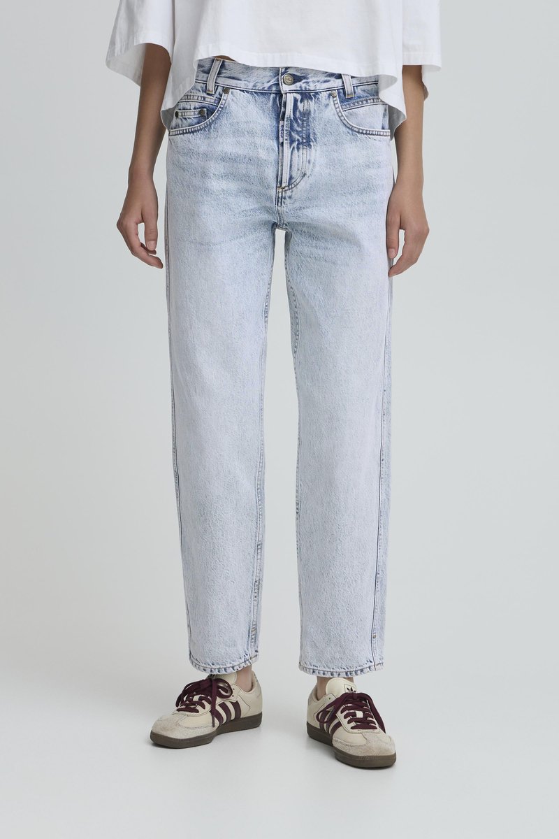 Svetlomodré džíny s rovnými nohavicami, s umelým opotrebovaním, piatimi vreckami a béžovými teniskami s bordovými akcentmi.