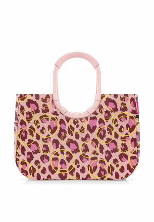 Sac fourre-tout rose avec des taches léopard rouge foncé et violettes ainsi que des visages souriants jaunes, doté de poignées rondes roses et d'une étiquette de marque rouge.