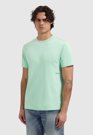 Mint green short-sleeve t-shirt made of soft cotton. Features a crew neckline and a small "PURE PATH" logo on the lower left side.