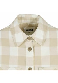 Camicia a quadri beige e bianca con colletto a bottoni, dotata di due bottoni e un'etichetta con la scritta "URBAN CLASSICS XS". Tessuto in cotone.