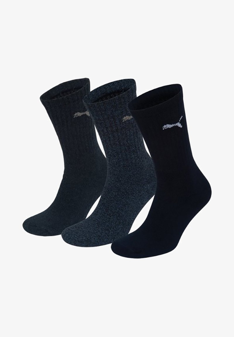 Tres pares de calcetines en tonos oscuros: uno azul marino liso, uno gris oscuro texturizado y uno negro acanalado, cada uno con un pequeño logotipo blanco.