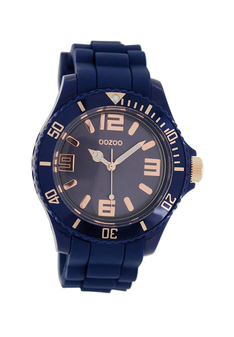 Montre en silicone marine avec un cadran rond, des aiguilles et des indices en or rose, et une lunette rotative avec des chiffres. Elle dispose d'un guichet de date à 3 heures.