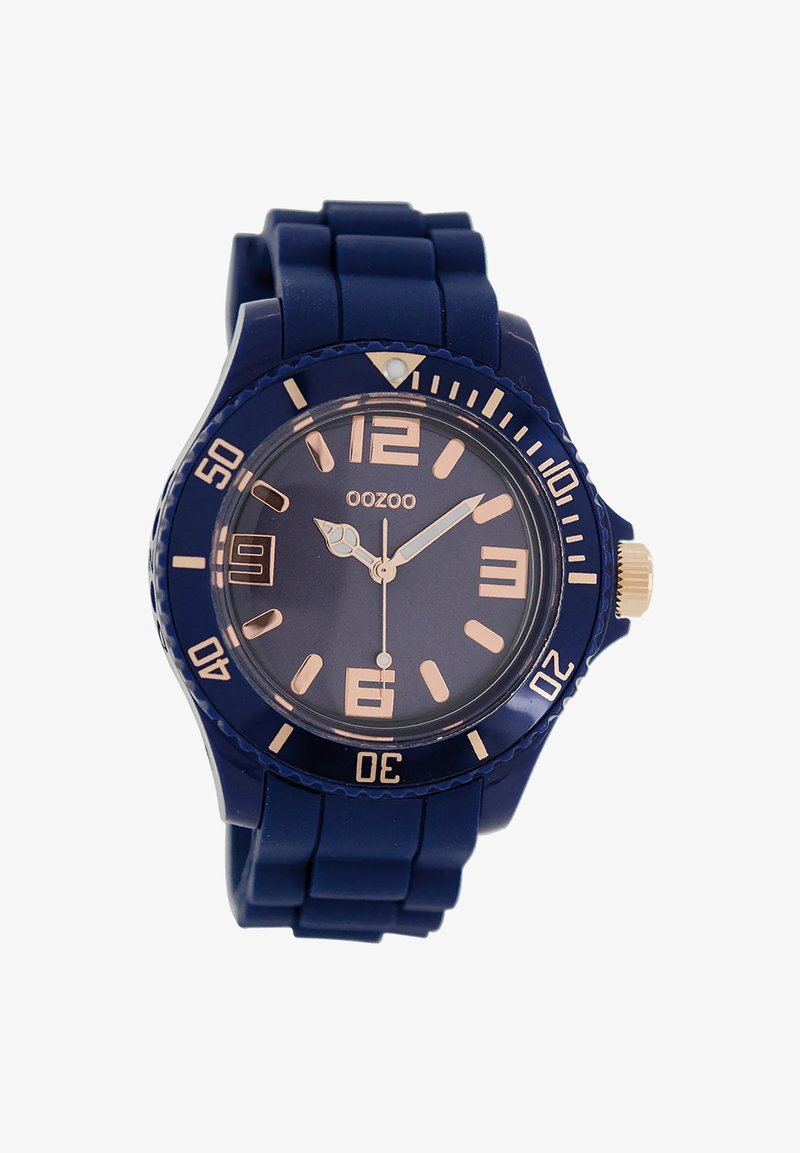 Montre en silicone marine avec un cadran rond, des aiguilles et des indices en or rose, et une lunette rotative avec des chiffres. Elle dispose d'un guichet de date à 3 heures.
