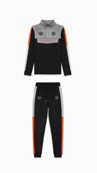 Zwarte sportieve trainingspak met een ritssluiting vest in grijs, oranje en zwarte kleurvlakken, en bijpassende broek met vergelijkbare designelementen.