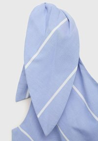 Vaaleansininen kangas, jossa on valkoisia vinoviivoja, ja sen yläosassa on kaksi suurta terävää läppää, mikä luo pitkänomainen muodon ja sileän tekstuurin.