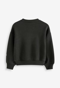 Svart oversized sweatshirt med rundad halsringning, ribbade ärmslut och fåll. Tillverkad av ett mjukt, texturerat tyg utan synliga mönster.