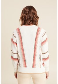Weißer Strickpullover mit rosa, beigen und braunen gestreiften Akzenten. Strukturierte Stoffqualität mit einem gerippten Saum und offenen Strickdetails entlang der Streifen.