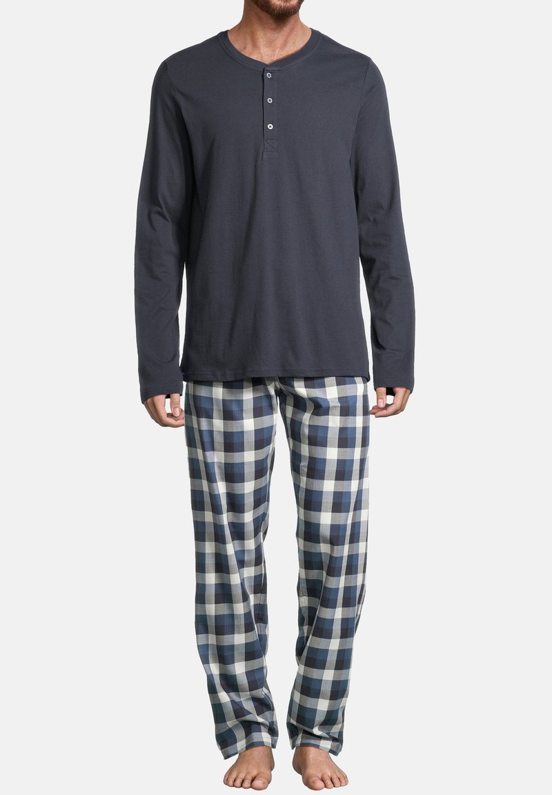 Chemise henley en coton bleu marine à manches longues avec des boutons. Pyjama à carreaux en bleu, blanc et gris. Coupe décontractée avec un pantalon ample.