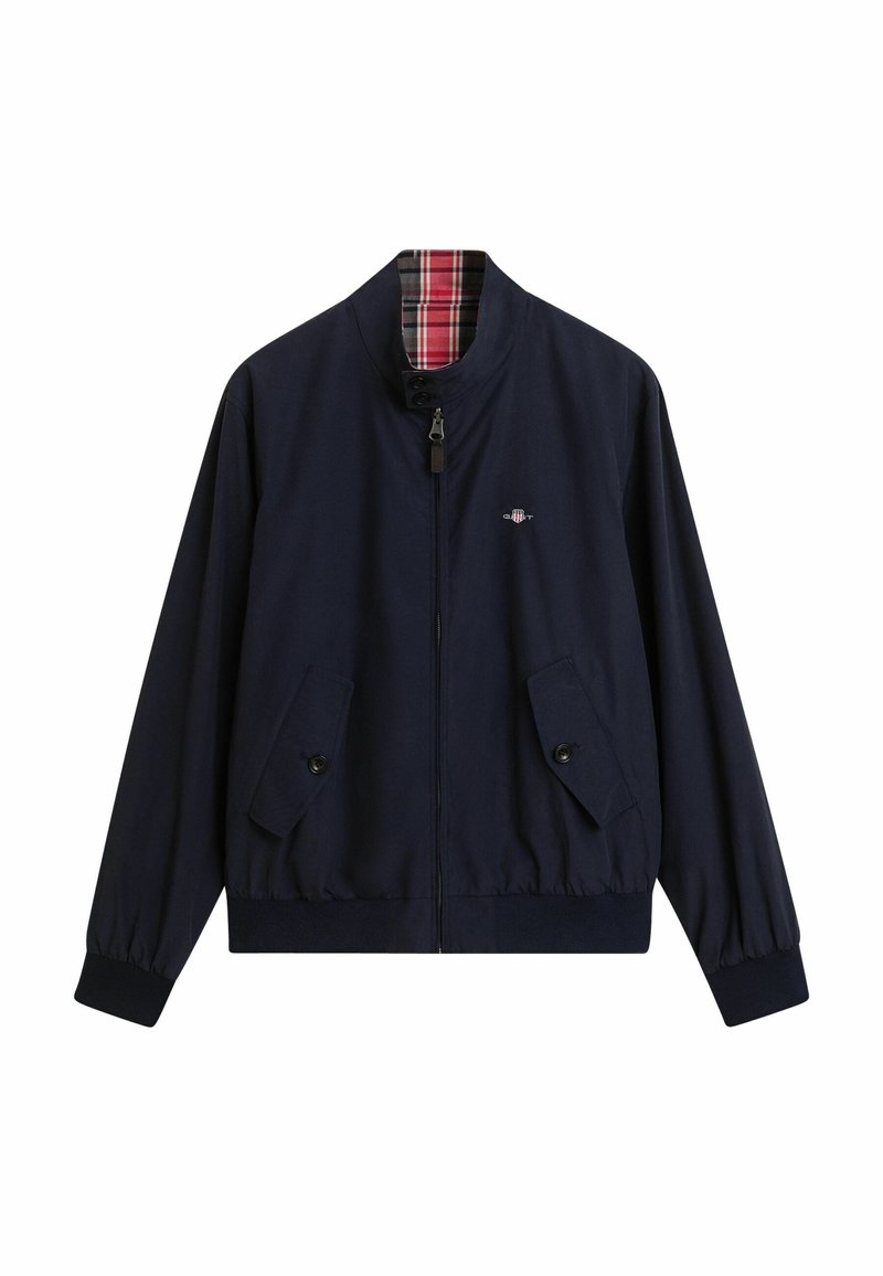Chaqueta bomber azul marina con cremallera en el frente, dos bolsillos con botón y forro de cuadros. Presenta un dobladillo y puños elásticos para un ajuste ceñido.