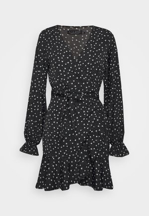 Robe portefeuille noire à manches longues avec imprimé floral blanc dispersé, taille nouée, encolure en V et ourlet et poignets à volants.