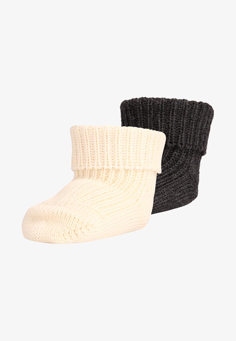 Knitted booties in cream and dark gray. Features a folded ribbed cuff. Soft texture with a rounded toe shape. Compact design for comfort.