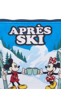 Topolino e Minni Mouse su uno sfondo blu, che tengono in mano tazze color turchese, circondati da montagne innevate e alberi sempreverdi. Testo "APRÈS SKI" sopra.