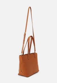 Brun läder axelväska med en strukturerad design, som har två kortare handtag och en avtagbar längre rem, mjuk textur och gulddetaljer.