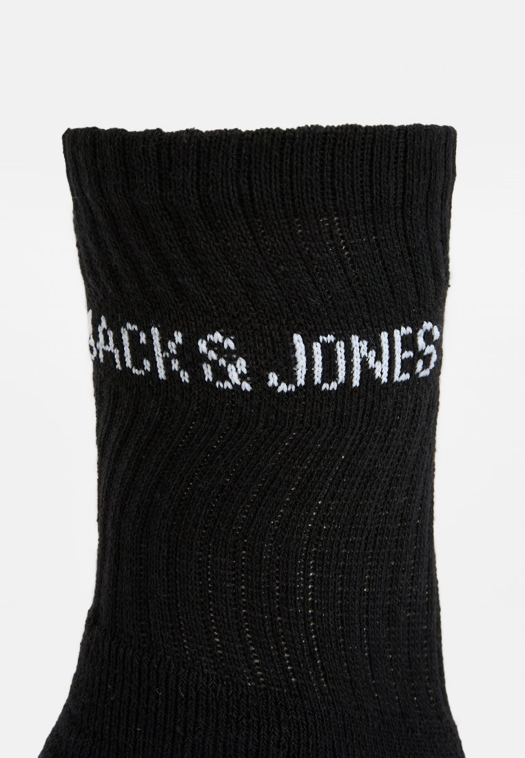 Czarna skarpetka prążkowana z białym napisem "JACK & JONES" wydzierganym wokół mankietu.