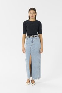Black cropped top with a round neck, paired with a high-waisted blue denim maxi skirt featuring a front slit and frayed hem. Accented with a black belt.