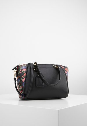 Sort håndtaske med blomsterprint på siderne, to top-håndtag og en aftagelig skulderrem, placeret på en hvid overflade mod en ensfarvet baggrund.