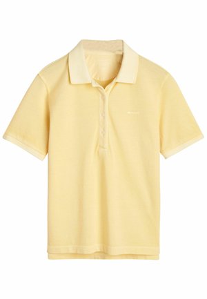 Polo in giallo chiaro, maniche corte, apertura con tre bottoni e texture morbida. Presenta un piccolo logo sul petto e un colletto a contrasto.