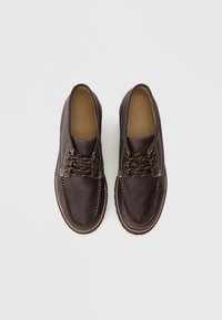 Braune Lederschuhe mit abgerundetem Zehenbereich, kontrastierender Naht, metallischen Ösen und braunen Schnürsenkeln. Glatte Oberfläche und gepolsterte Innensohlen.