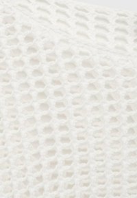 Tissu en tricot blanc avec un motif ajouré hexagonal, présentant une texture douce et une apparence légère, idéal pour le superposition.