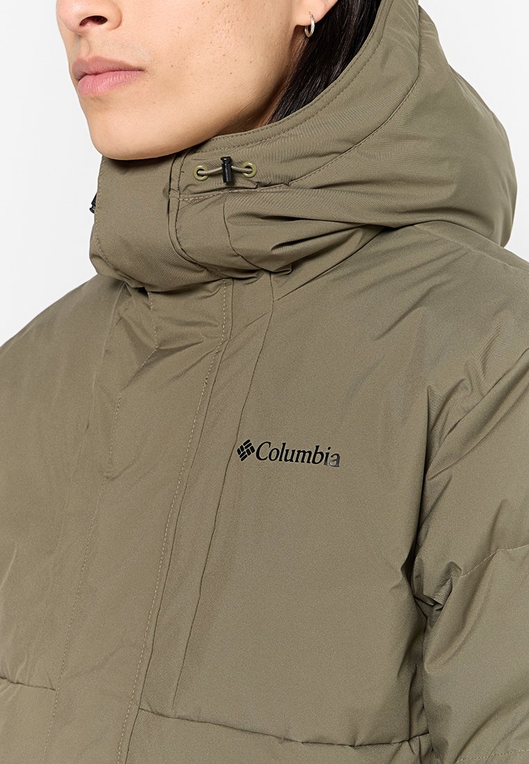 Veste doudoune vert olive avec un col haut, une capuche à cordon de serrage et un logo Columbia bien visible. Fabriquée en tissu texturé avec un design matelassé.