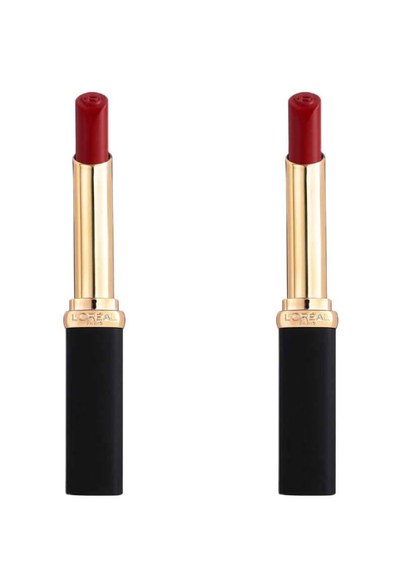 Rouge à lèvres dans un tube doré et noir. Le haut du tube est doré avec une pointe arrondie, et la base est noire mate avec un logo.