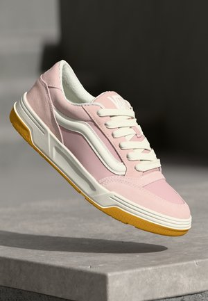 Rosa sneakers med vita accenter, med en slät ovandel, vadderad plös och gul gummisula. Snörningsdesign för en säker passform.