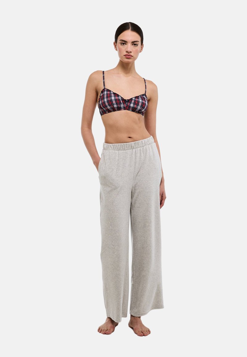 Bralette à carreaux en rouge, blanc et marine, avec des bretelles fines ; pantalon de survêtement gris à jambes larges, en tissu doux, avec une ceinture élastique.
