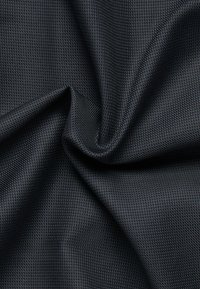 Schwarzer Netzstoff mit einem gitterartigen Muster, glatter Textur und leichtem Glanz, gefaltet, um Tiefe und Eigenschaften der Webart zu zeigen.