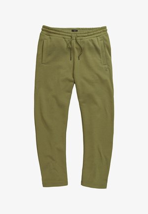 Joggingbukser i olivengrøn med elastisk talje, snor, sidelommer og subtilt "JP"-logo på venstre lår.