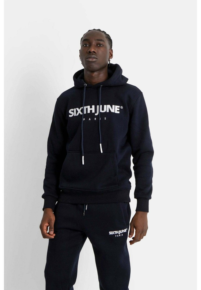 Marinblå hoodie med framficka, dragsko och vit "SIXTH JUNE PARIS"-logotyp. Tätt passform kompletteras av matchande joggers.