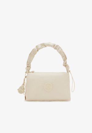 Beige handbag made of smooth material with a gathered handle, featuring a circular logo and a small charm in the shape of a face.