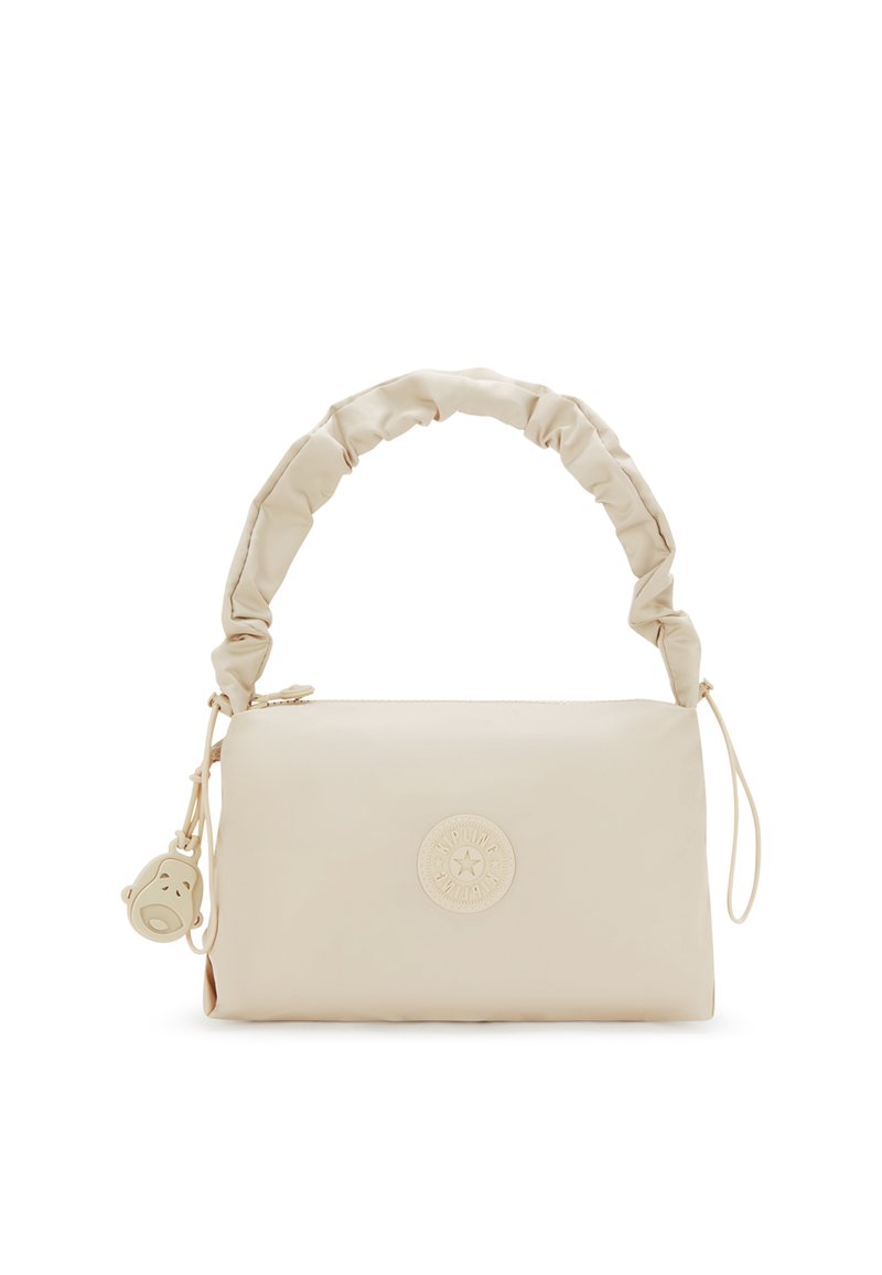 Beige handväska i slätt material med en rynkad handtag, prydd med en cirkulär logga och en liten charm i form av ett ansikte.