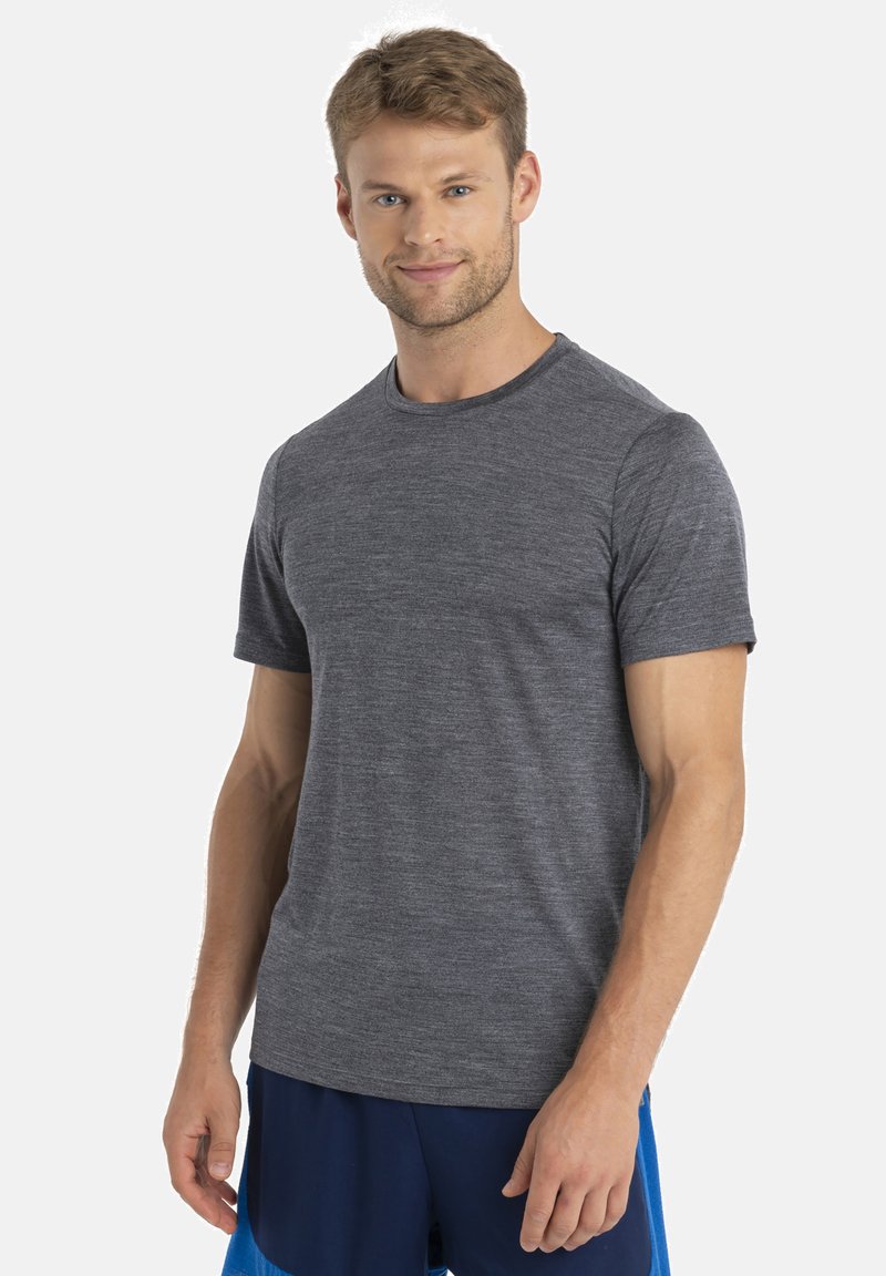 Graues, kurzärmliges T-Shirt aus einem weichen, strukturierten Stoff mit klassischem Rundhalsausschnitt, getragen mit blauen Shorts für den Kontrast.