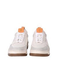 Sneaker bianche con dettagli in suede grigio, suola in gomma testurizzata, lacci piatti e etichette arancioni con tre linee verticali.