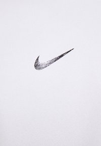 Tessuto di cotone bianco con un logo Nike metallico argento. Il materiale è liscio con una texture sottile. Il logo è posizionato centralmente.