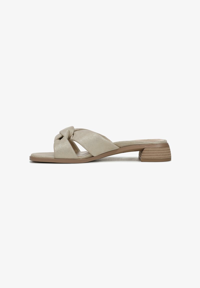 Sandales à talon bas nouées de couleur beige, fabriquées en matériau lisse, avec un design à bout ouvert. Texturées avec une finition douce et brillante.