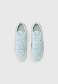 Light blue athletic shoes with mesh and suede materials, featuring turquoise laces, a silver accent, and a textured outsole.