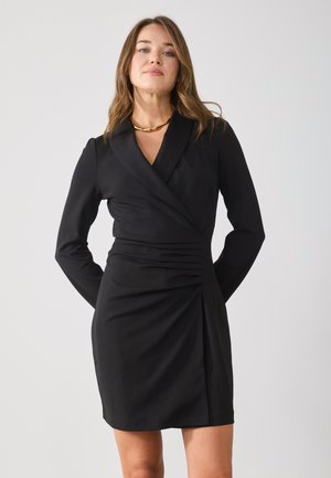 Schwarzes Wickelkleid mit langen Ärmeln, das über ein tailliertes Design, Falten an der Taille und eine glatte Stoffstruktur verfügt.