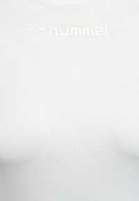 Kompressionsshirt in Weiß, hergestellt aus strukturiertem synthetischem Material. Verfügt über ein dezentes Markenlogo in heller Farbe am Kragen.