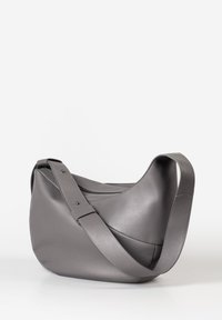 Graue Leder-Schultertasche mit geschwungener Form, verstellbarem Riemen und feinen Nähdetails. Glatte Textur, minimalistisches Design.