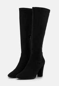 Bottes noires montantes jusqu'au genou en daim à finition lisse, dotées d'un bout pointu et d'un talon bloc modéré, avec fermeture éclair latérale.