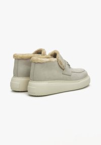 Grijze suède sneakers met een bontvoering en een dikke witte zool. Heeft een strap over de bovenkant met een logo-detail.