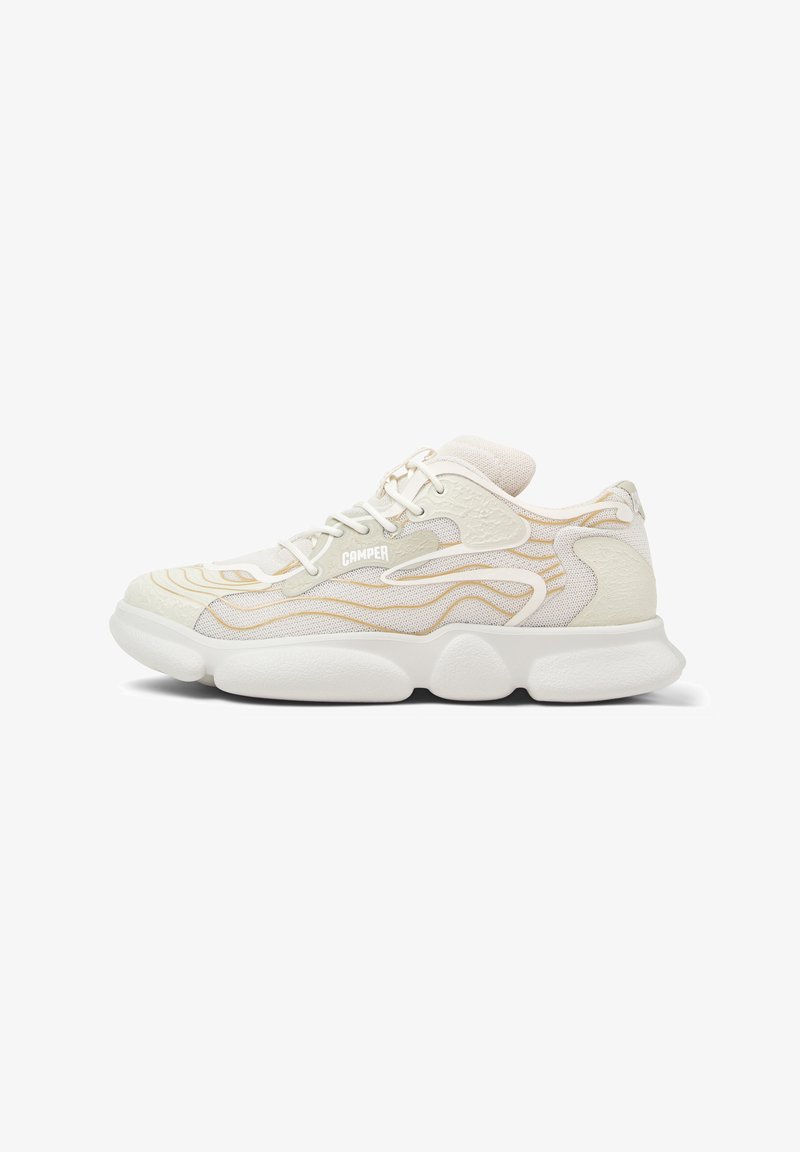 Sneakers bianchi con un upper testurizzato, caratterizzati da accenti ondulati dorati, punta rotonda e una suola bianca spessa. Sono visibili i lacci e il marchio.