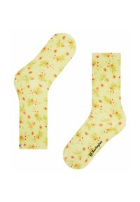 Gelbe Socken mit einem floralen Muster, das rosa und orange Blumen auf einem hellgrünen Hintergrund zeigt. Am Fußsohle befindet sich ein Logo.