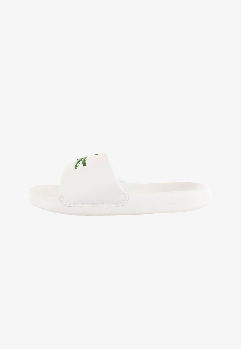 White slide sandal made of synthetic material. Features a smooth upper with a green logo and a textured, cushioned footbed.