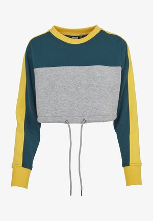 Rövidített pulóver, szürke testen, türkiz kargyűrűkkel és sárga részletekkel. Állítható méretet biztosító húzózsinórral és fémalkatrészekkel rendelkezik.