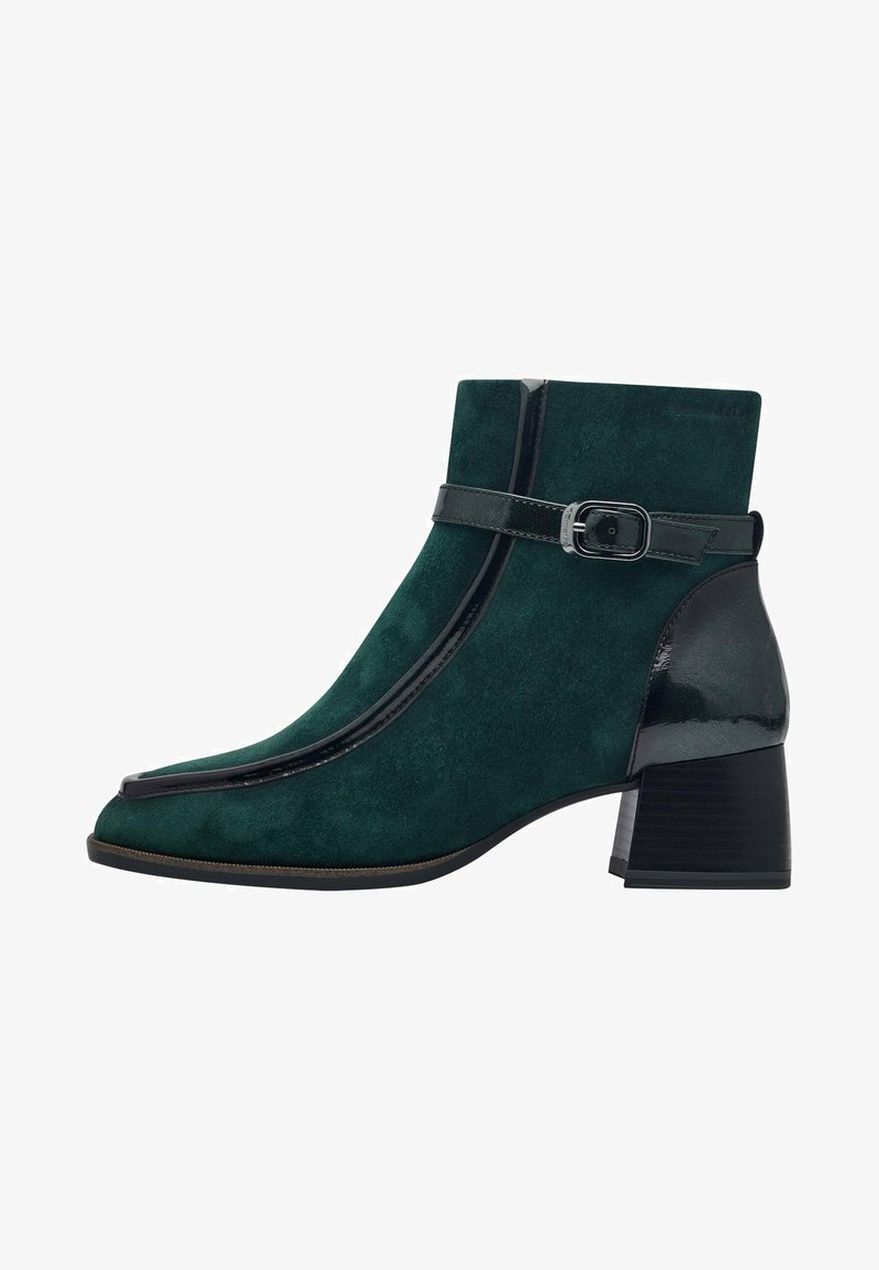 Stivaletto alla caviglia verde in suede con un accento in pelle nera lucida, punta appuntita e una fascia sottile con fibbia argentata. Design con tacco a blocco.